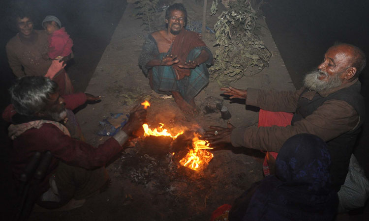 শীত পড়ায় রাস্তার পাশে আগুন জ্বালিয়ে শীত নিবারণ করছেন অনেকে