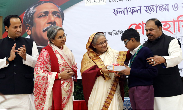 গণ ভবনে শিক্ষার্থীর হাতে বই তুলে দিচ্ছেন প্রধানমন্ত্রী শেখ হাসিনা