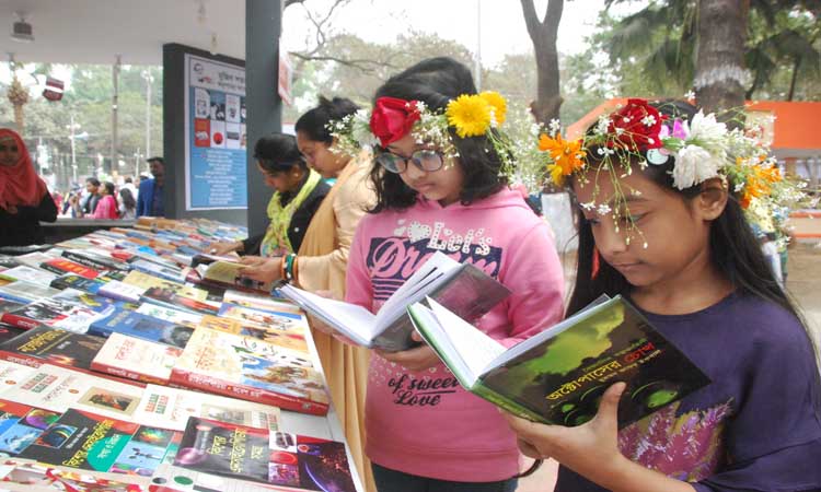 বইমেলায় একটি স্টলে বই দেখছে শিশুরা