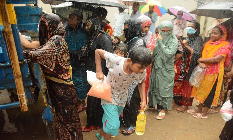 রাজধানীতে বৃষ্টিতে ভিজে টিসিবির পণ্য কিনছেন নিম্ন আয়ের মানুষ।