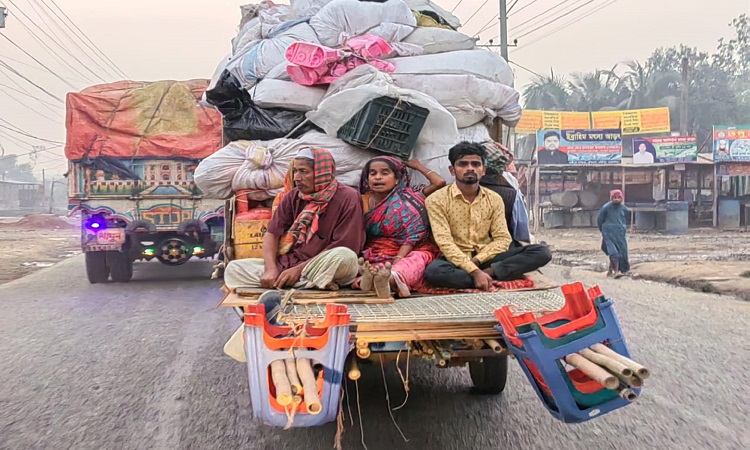 বাসা পাল্টাতে পিকআপ ভ্যানের পেছনে বসে জীবনের ঝুঁকি নিয়ে গন্তব্যে যাচ্ছেন এক পরিবারে তিন সদস্য। ঘটতে পারে দুর্ঘটনা। ময়মনসিংহ-কিশোরগঞ্জ মহাসড়কের গৌরিপুর এলাকা থেকে শুক্রবার তোলা ছবি।