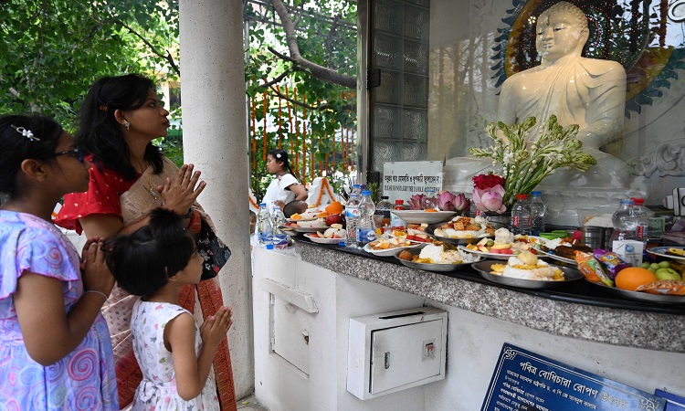 বৌদ্ধদের প্রধান ধর্মীয় উৎসব বুদ্ধ পূর্ণিমা বা বৈশাখী পূর্ণিমায় বৌদ্ধ মূর্তির সামনে  প্রার্থনারত পুণ্যার্থীরা। ঢাকার মেরুল বাড্ডা আন্তর্জাতিক বৌদ্ধ বিহার থেকে তোলা ছবি।