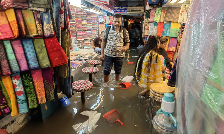 সোমবারের বৃষ্টিতে রাজধানীর ধানমন্ডি হকার্স মার্কেটের ভেতরে নোংরা হাঁটুপানি। ক্রেতা যারা আসছেন হাঁটুপানিতে নেমেই করছেন কেনাকাটা।