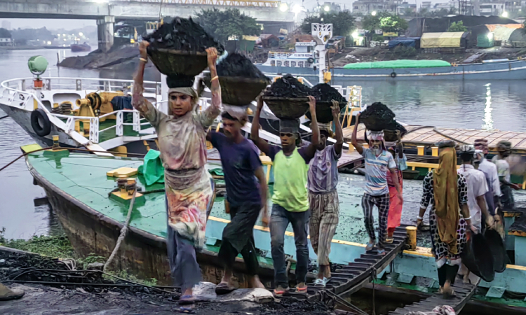 সাভারের আমিনবাজারে বুড়িগঙ্গার তীরে কয়লা নামানোর ব্যস্ততা। কয়লা নামাতে ঝুড়িপ্রতি দেওয়া হয় পৌনে চার টাকা।