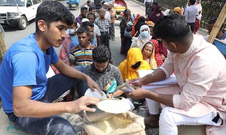 ওএমএসের ট্রাকসেল থেকে চাল ও আটা সংগ্রহ করতে সাধারণ মানুষের ভিড়। ছবিটি মঙ্গলবার রাজধানীর আব্দুল গণি রোড থেকে তোলা।